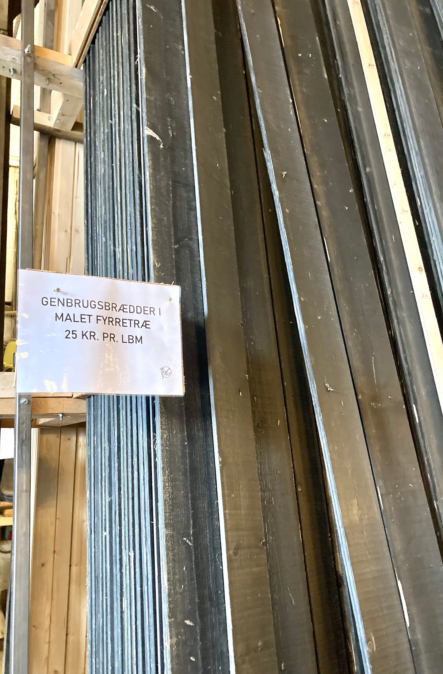 Sortmalede fyrretræsbrædder, der stammer fra et nedrivningsprojekt og som nu er klar til at få nyt liv. Brædderne kan bruges til renovering eller reparation.