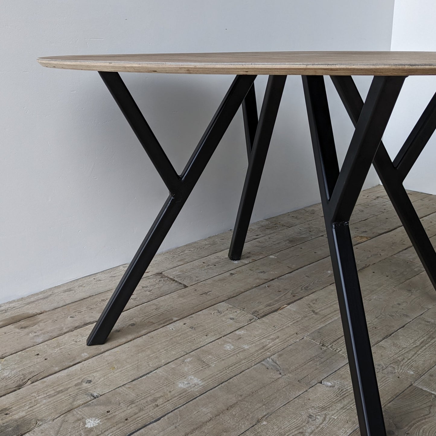 Sildebensbord med Y-stel - specialproduceret i Aalborg. Sildebensbordpladen er lavet på en overskudsplade, hvor værkstedet har pålimet og bearbejdet vinyl med 20% havplast fra Garant i et sildebensmønster.