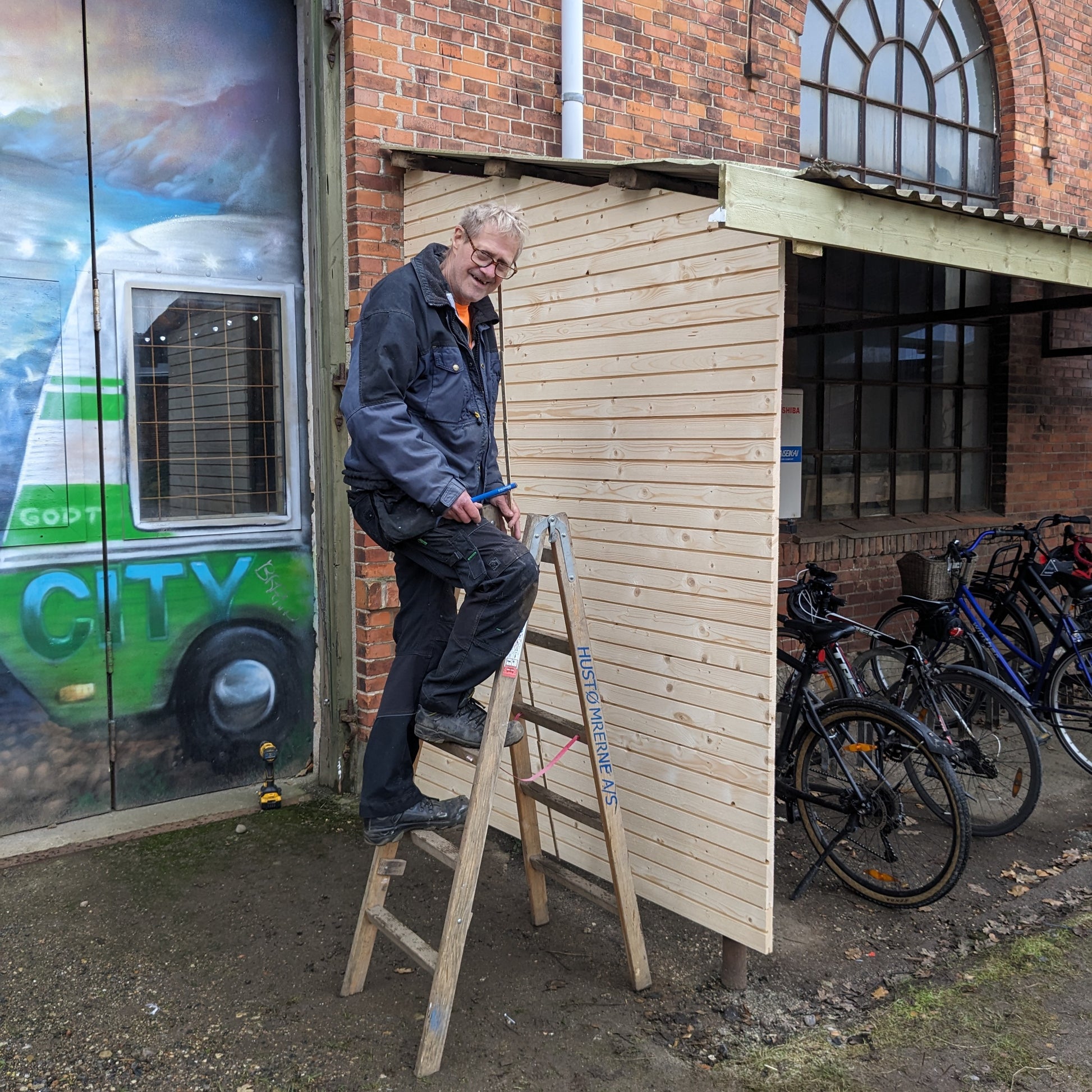 Her ses vores frivillige tømrer Jens med et cykelskur lavet af produktet 