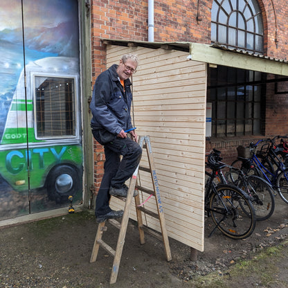 Her ses vores frivillige tømrer Jens med et cykelskur lavet af produktet 