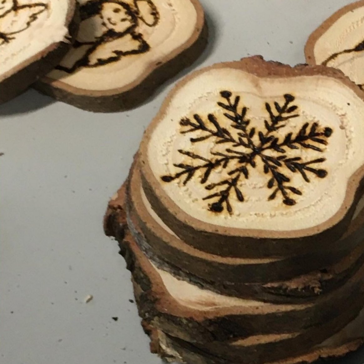 R&G juletræspynt - skiver af genbrugte juletræer - håndlavet julepynt - håndbrændte motiver. Socialansvarligt produceret. Produceret i samarbejde med unge fra kanten af arbejdsmarkedet. Råt&Godt - fordi mennesker og materialer fortjener en chance til.