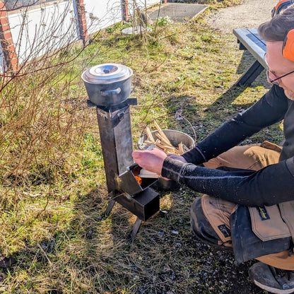 Her ses en af Råt&Godts medarbejdere tænde op i rocket stove.