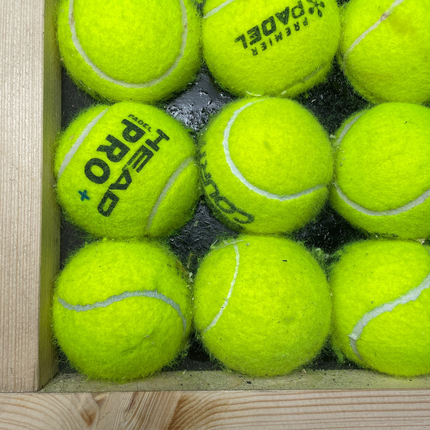 Nærbillede af vægbeklædning af halve tennisbolde i en træramme