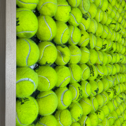 Vægbeklædning af halve tennisbolde i en træramme