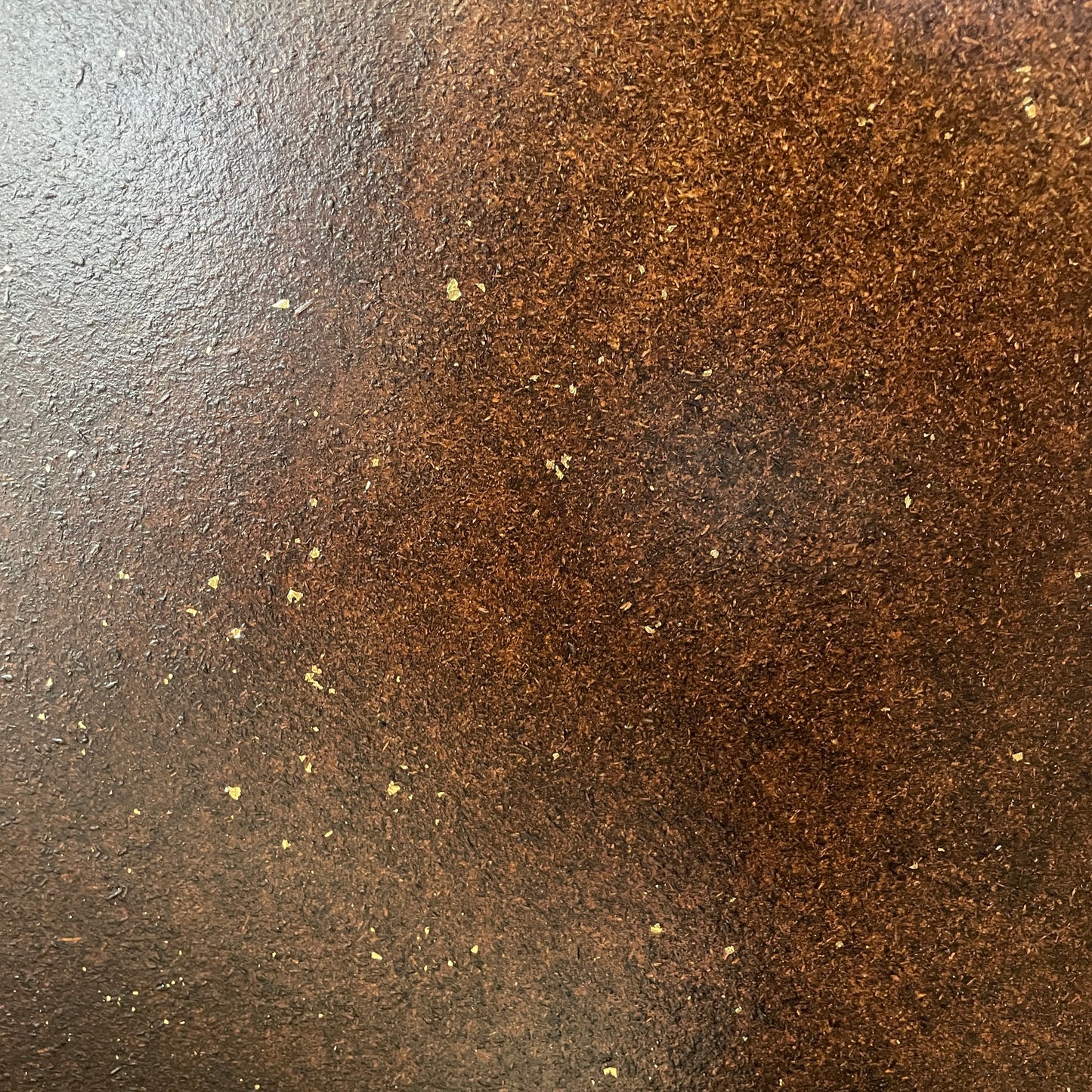 Nærbillede af brun vægbeklædning med guldflager