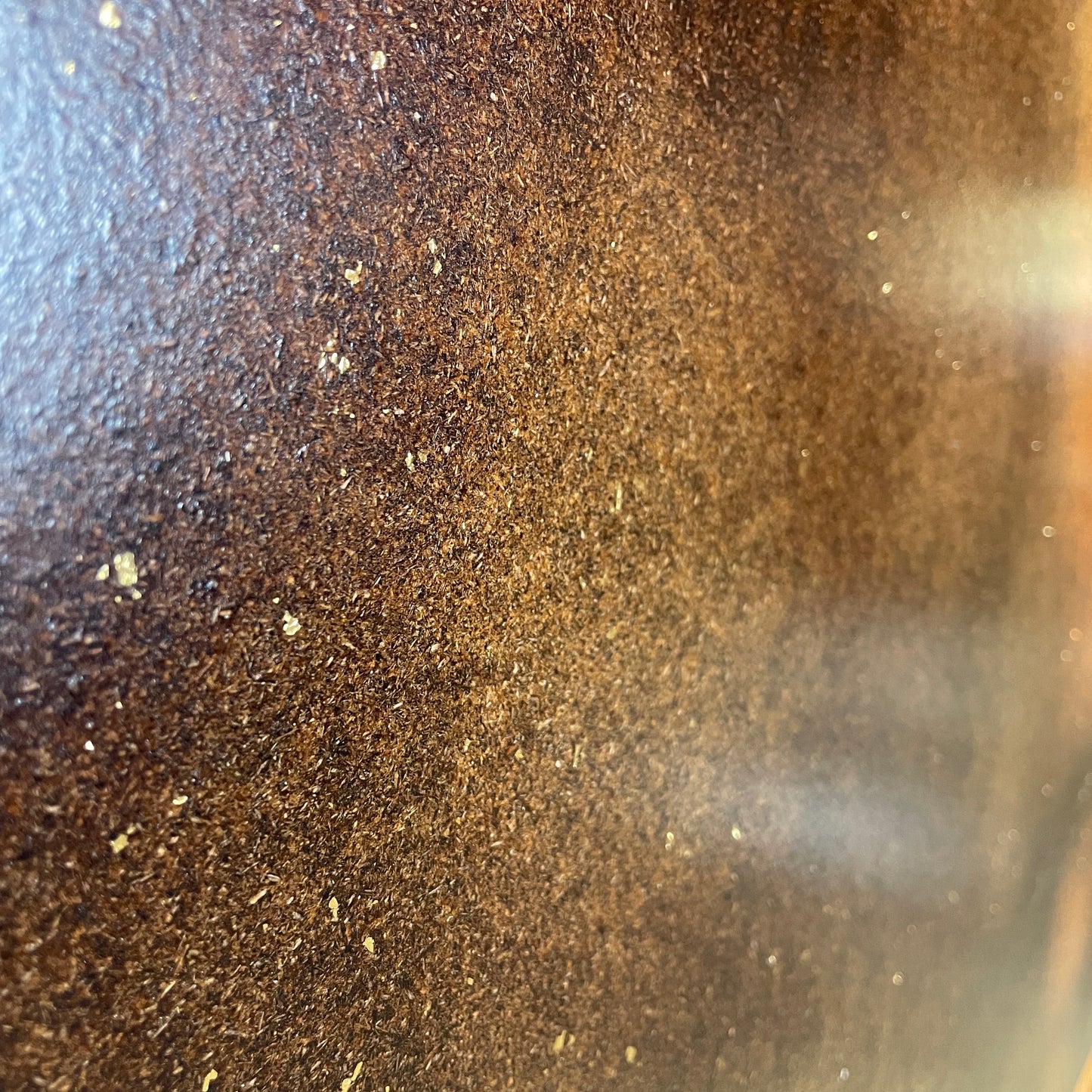 Nærbillede af brun vægbeklædning med guldflager