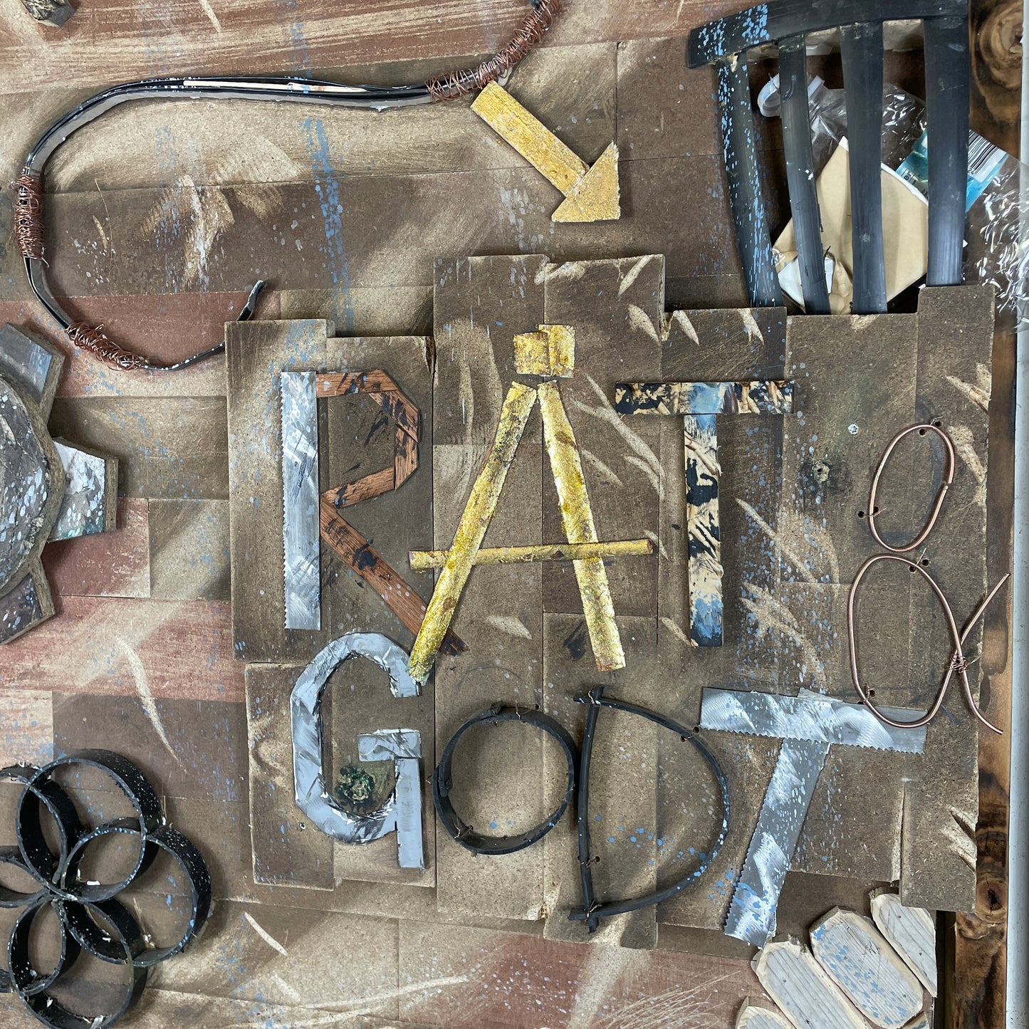 vægbeklædning med motiv af blandt andet tandhjul, skraldespand, lænker der knækkes med hænder og teksten "Råt & godt"